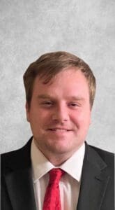 A man in suit and tie smiling for the camera.