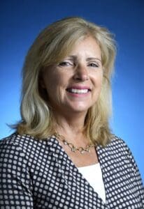 A woman with blonde hair and a black jacket.